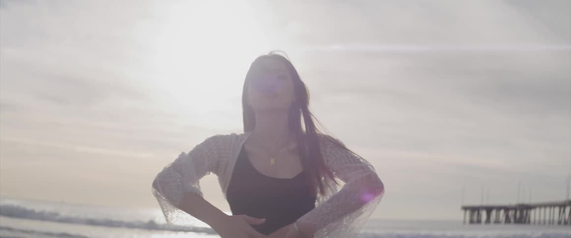 A young woman dancing on the beach