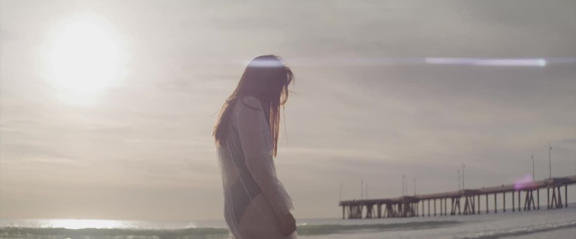 A woman walks slowly on the beach