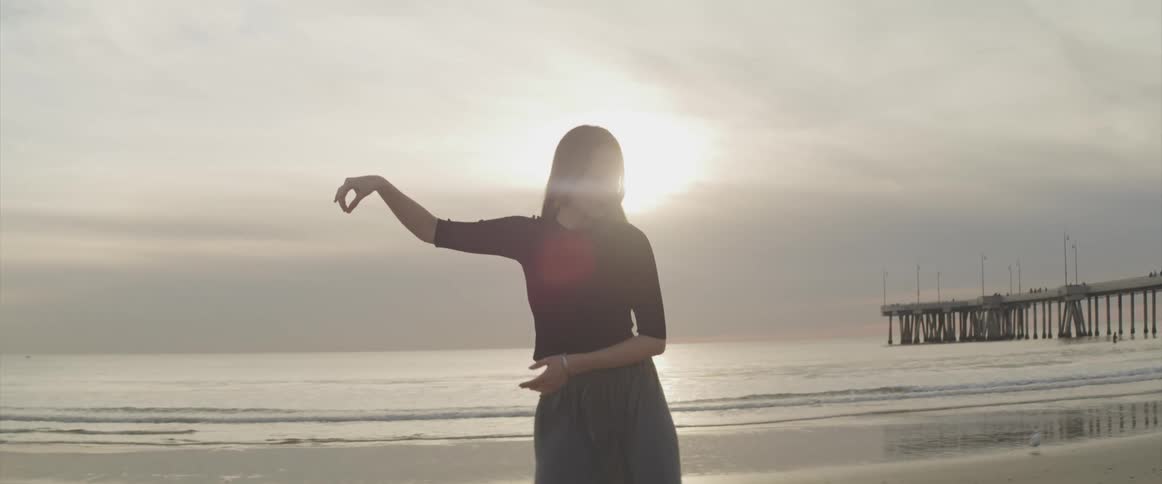 A woman is stretching outdoors at the beach