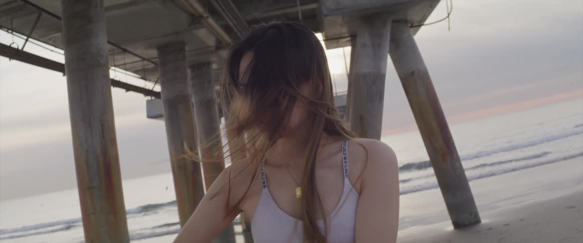 A woman is stretching outdoors at the beach