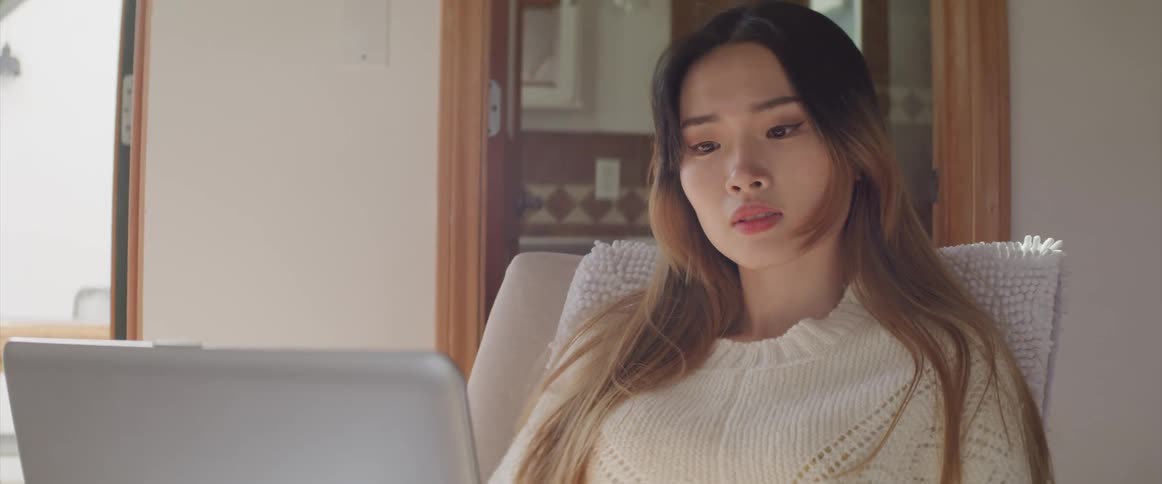 A woman sitting at home using her laptop