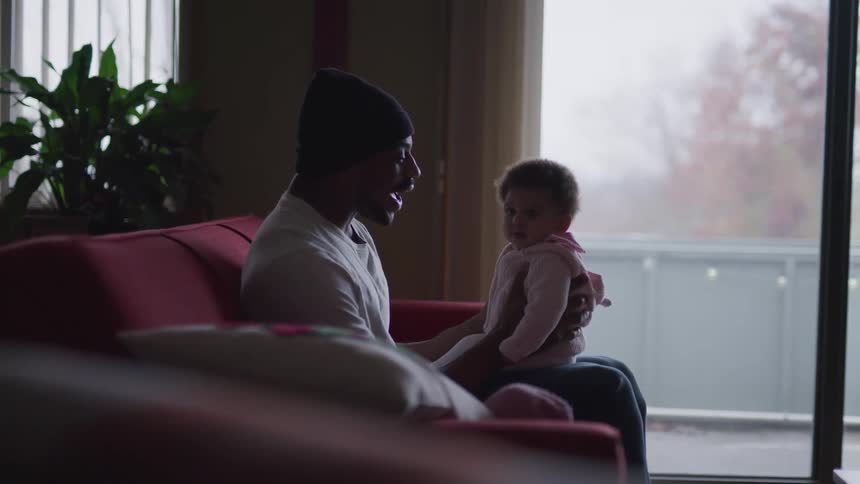 Father sitting on the couch holding his infant son