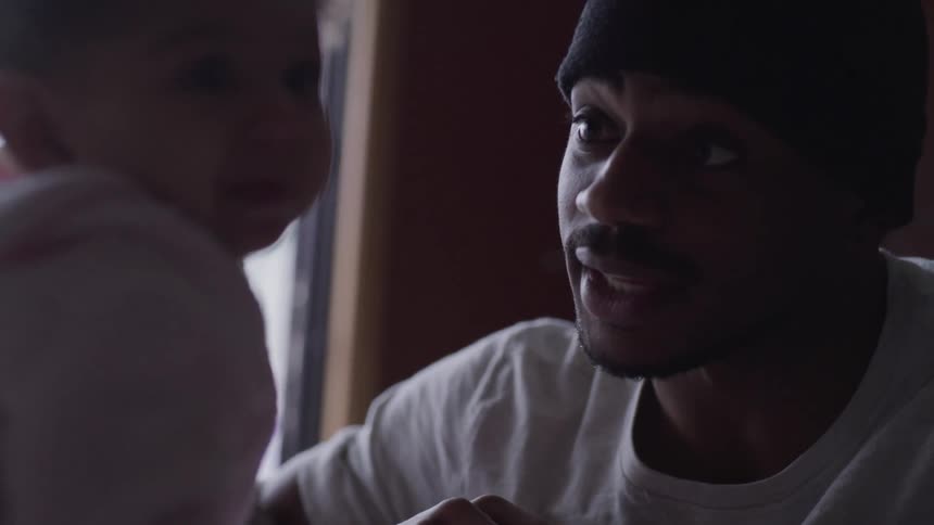 Father wearing knit cap talks to daughter wearing a pink lined hoodie