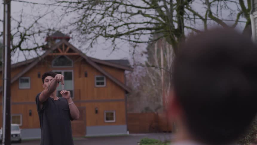 A man throws a football to a younger boy