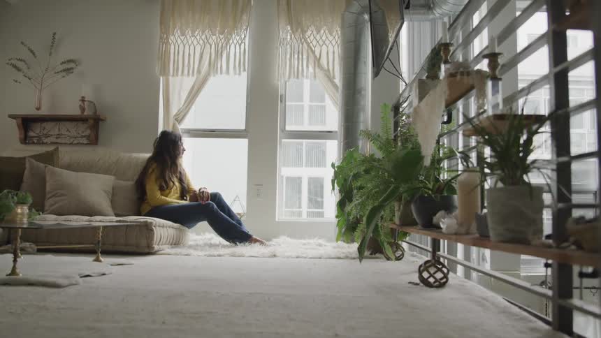A woman is sitting in a house alone