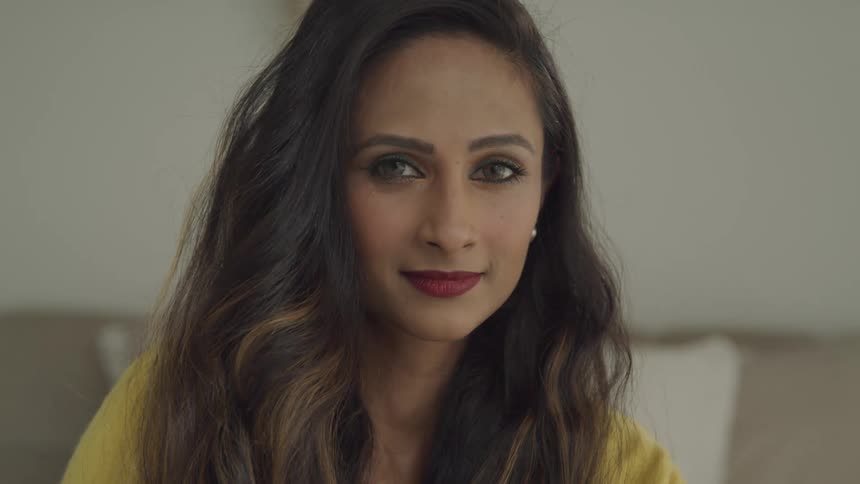 A woman is smiling in a room indoors