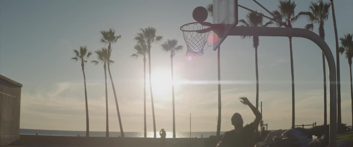 A man shooting a basketball into a hoop