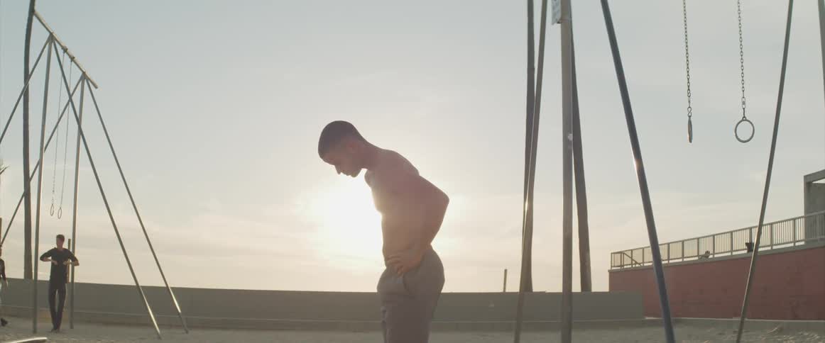 A man is working out at the beach at dusk