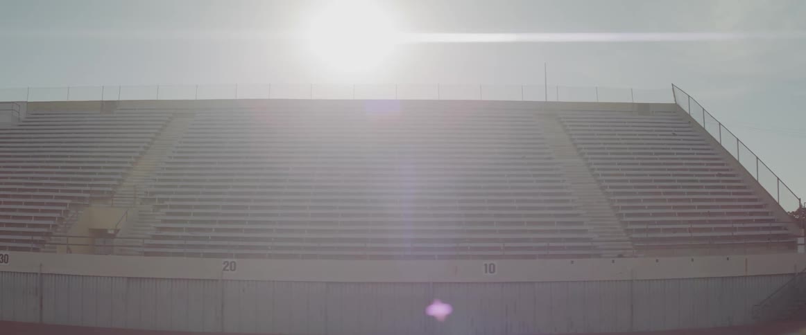Empty bleachers sit under the bright sun