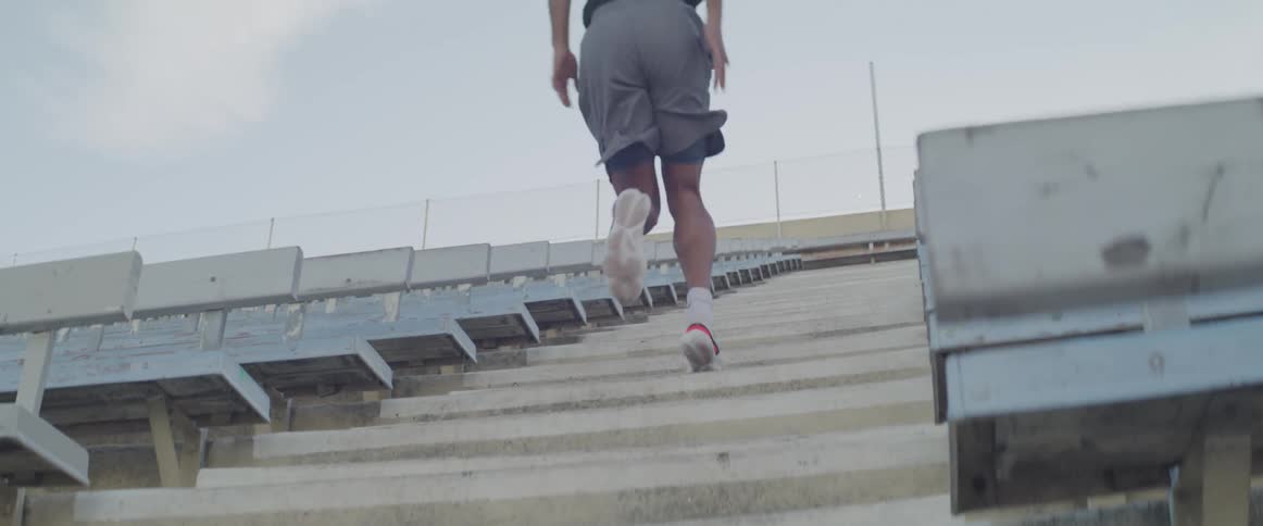 Male running up stadium stairs during workout