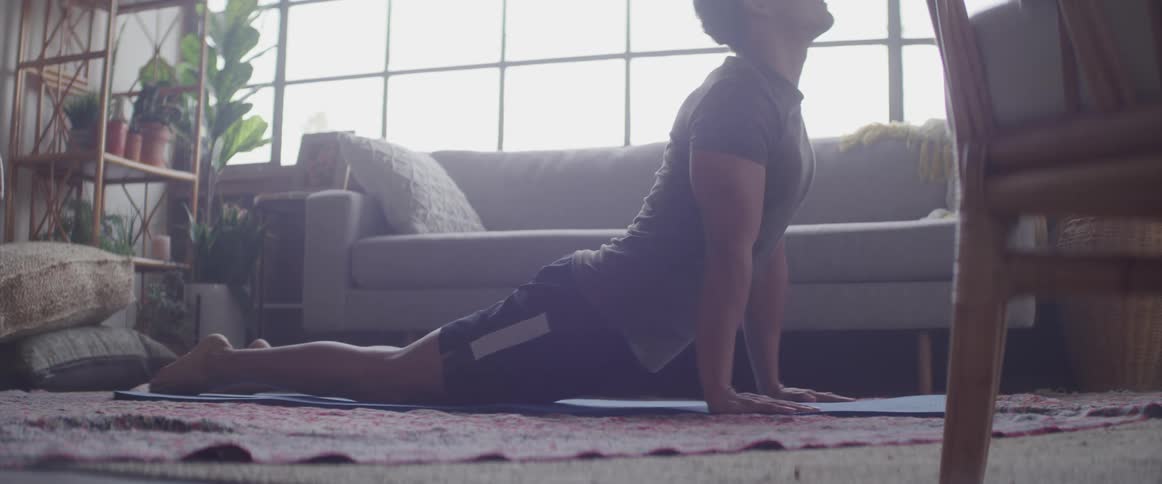 A man pushes his body off of the floor in a yoga pose