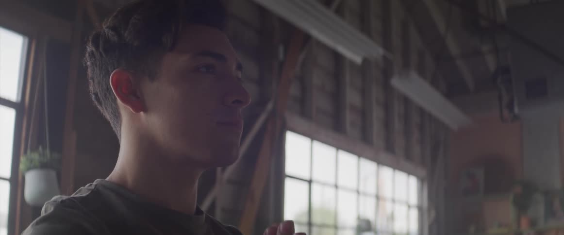 A teenager boy praying in a building
