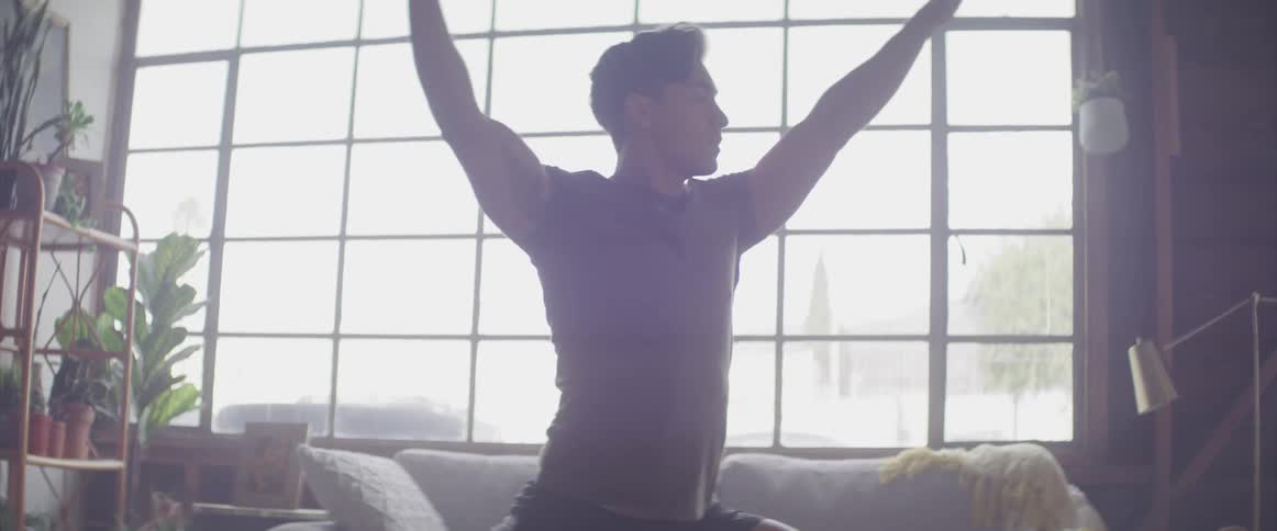 A man stretches down and back up again in a yoga pose