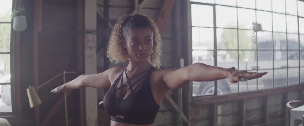 A woman is stretching in a room indoors