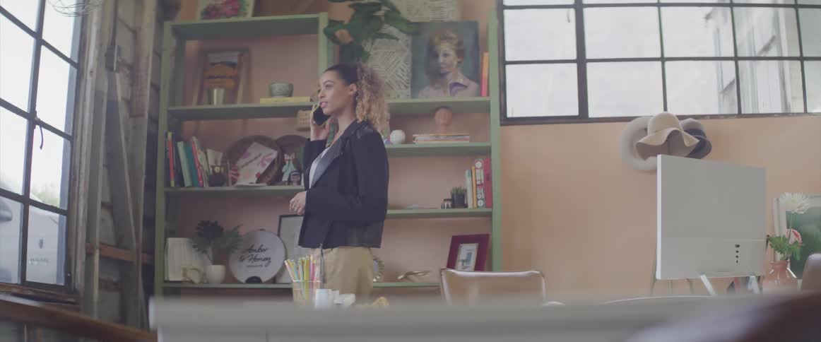 A young woman at home talking on the phone