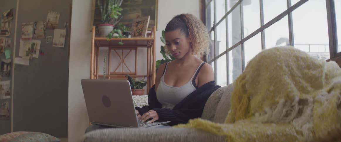 A woman is typing on the laptop