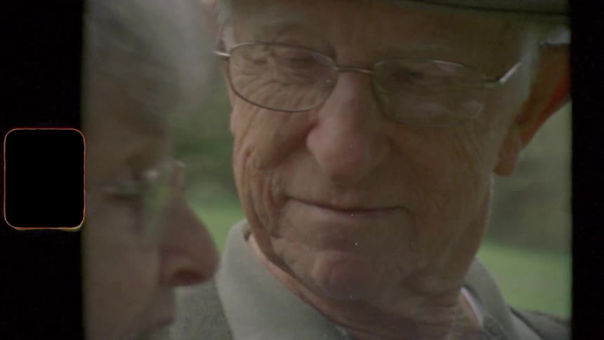 Elderly man with glasses looks at elderly woman and they talk to each other