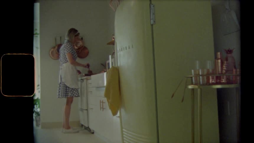 Vintage footage of a woman cooking in her kitchen