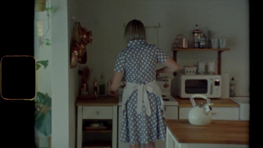 Woman wearing an apron stirs something on the stove