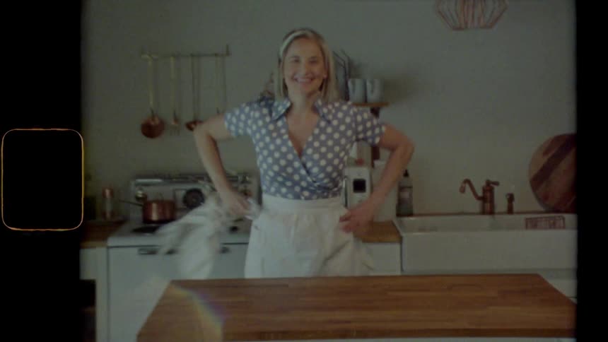 Woman rapidly cleans kitchen island then stands with hand on hips smiling