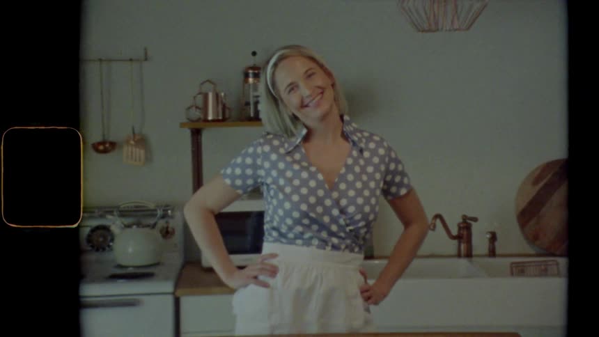 A woman is posing in the kitchen