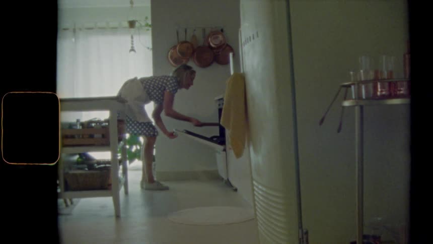 A woman takes a pan out of the oven