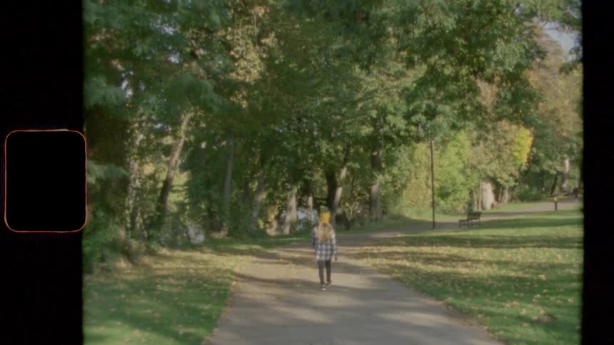 Vintage footage of a young girl walking in a park