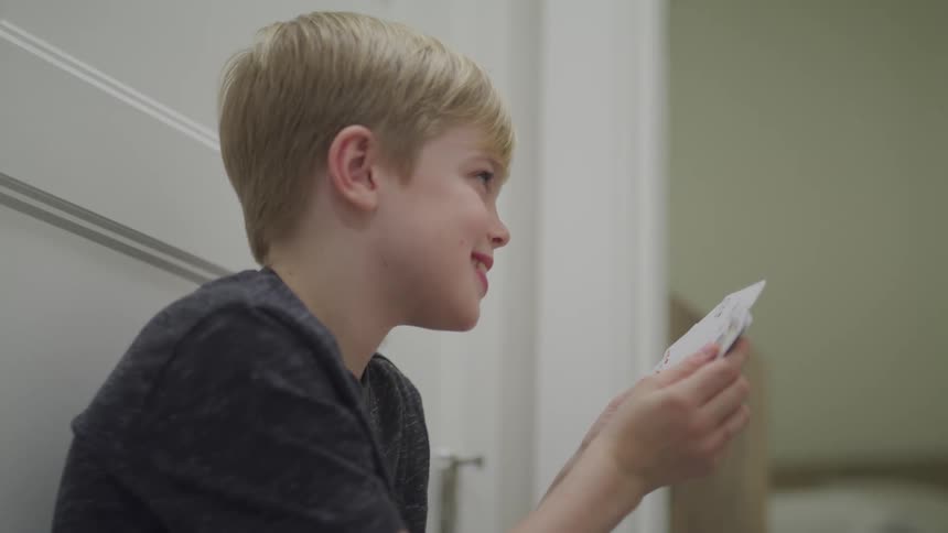 Boy smiling and looking at hand of playing cards