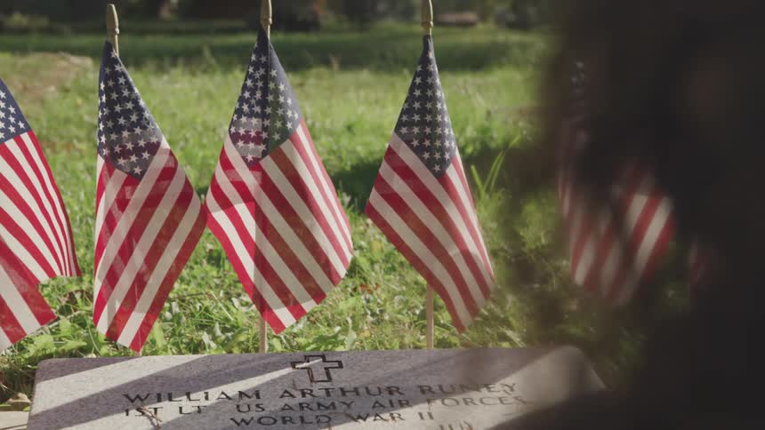 Grave of world war ii veteran surrounded by small flags