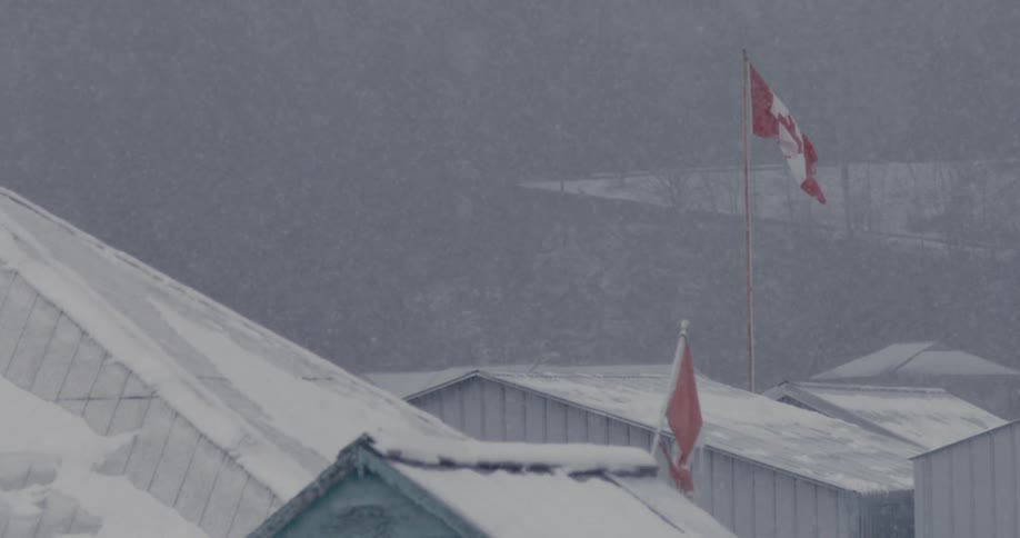 A town with a Canadian flag in heavy snowfall