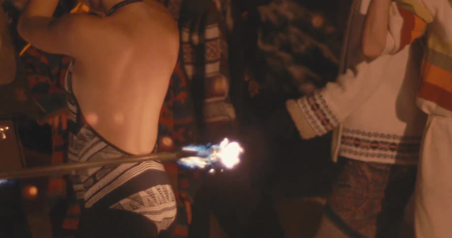 A fire dancer with a hula hoop at a bonfire party