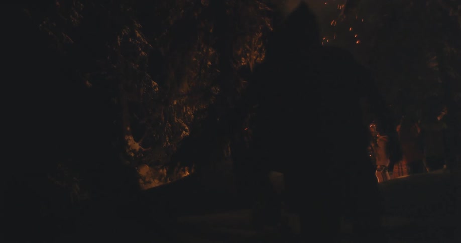 A group of people around a bonfire party outside