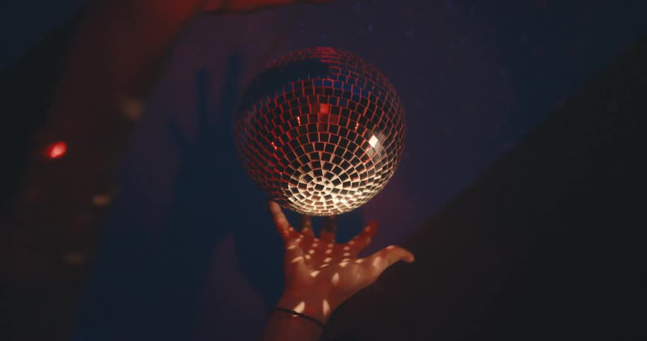 Hands wrap around a disco ball