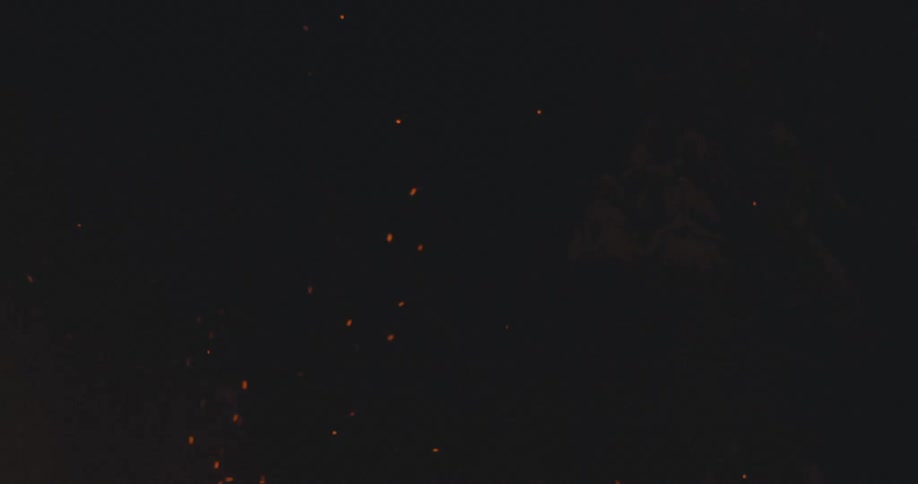Sparks rise from flames in the night