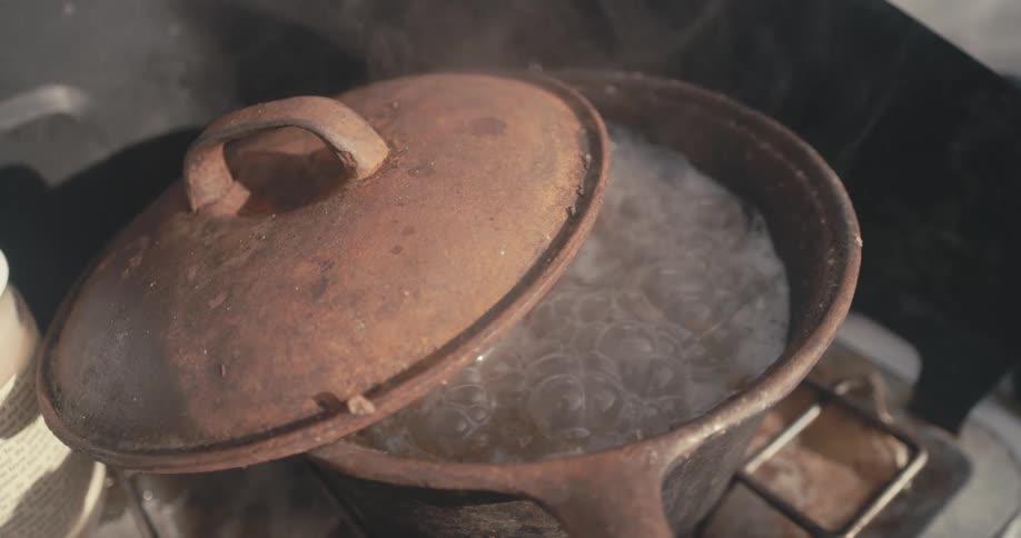 The pot of oatmeal is boiling in the sun