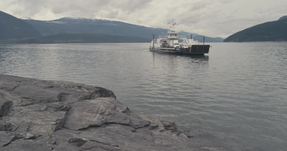 A ferry moves across a mountain lake
