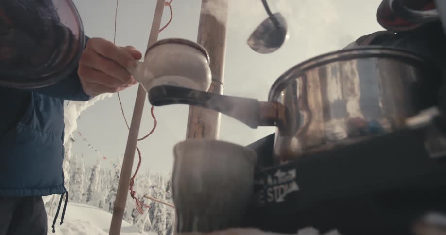 Campers serve soup or breakfast from a steaming pot