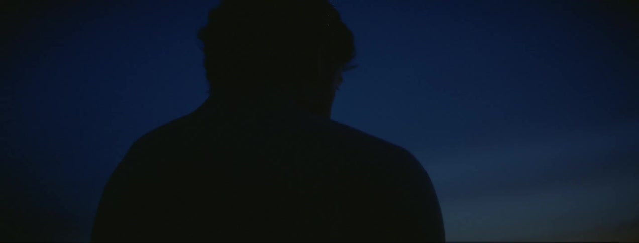 A man is standing outdoors atnight