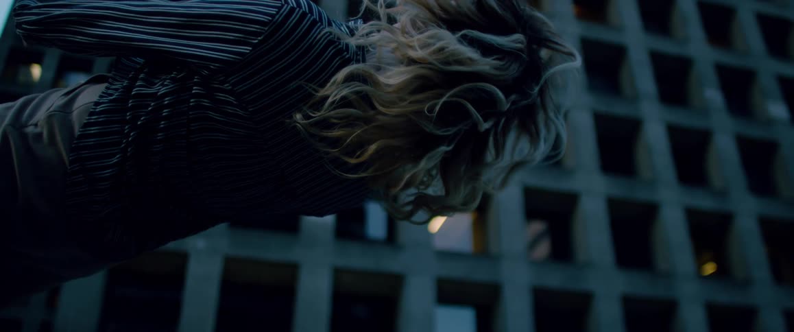 Upside down footage of a woman falling on her back in front of an office building