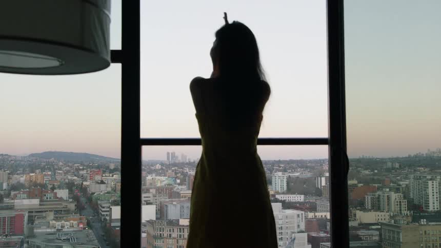 A woman claps near the window