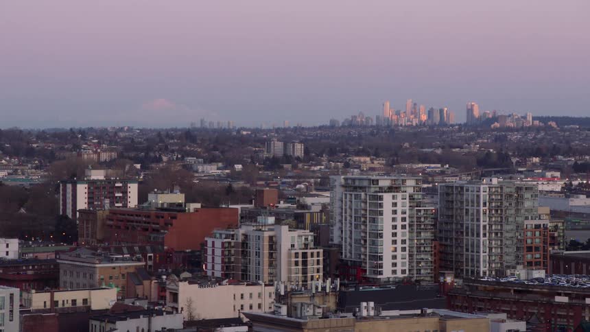 The buildings and rooftops of a city with skyscrapers and a city skyline on the horizon