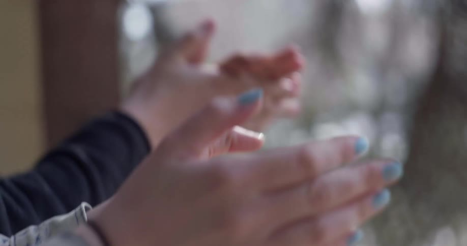 Two people clapping outside