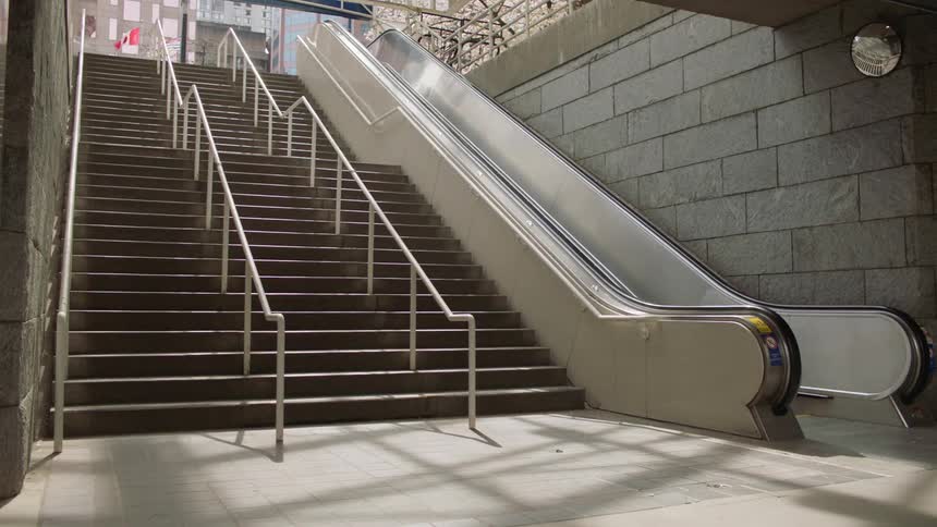 A man walks carrying a bag walks down stairs