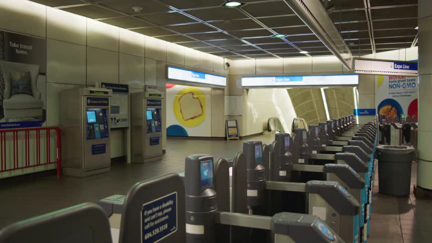 A person walking into a station with turnstiles