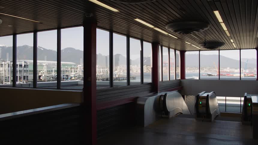 An escalator in a building in front of the water