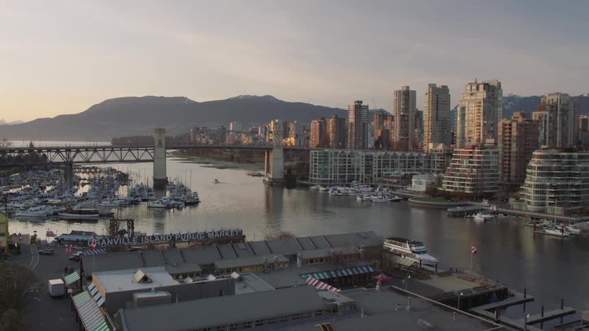 Skyscrapers line a harbor in an urban area