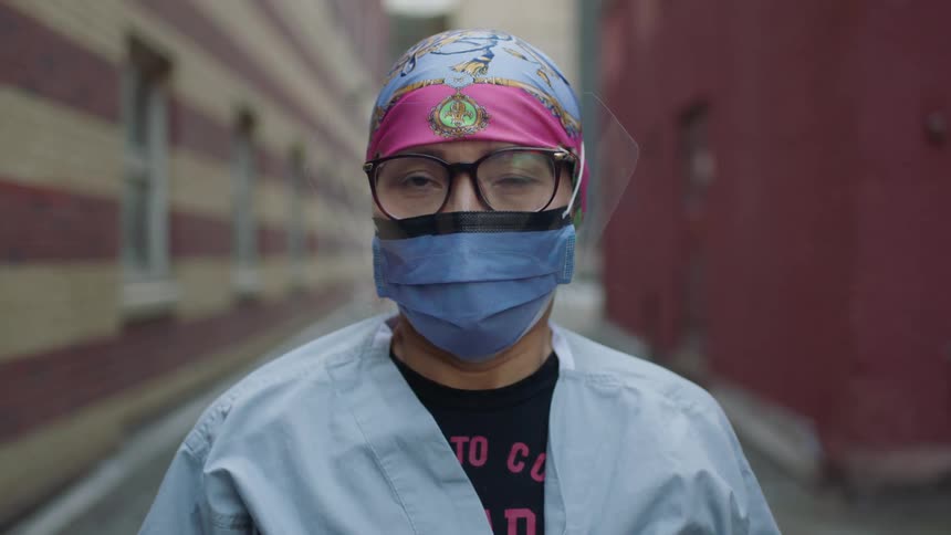 A man is standing outdoors with a mask and glasses