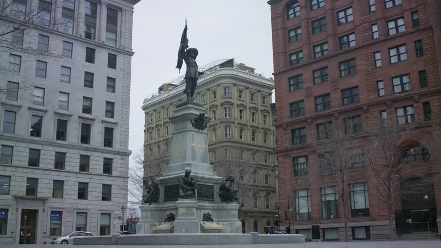 A monument in a city near tall buildings