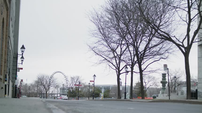 A single pedestrian walks in an empty city neighborhood