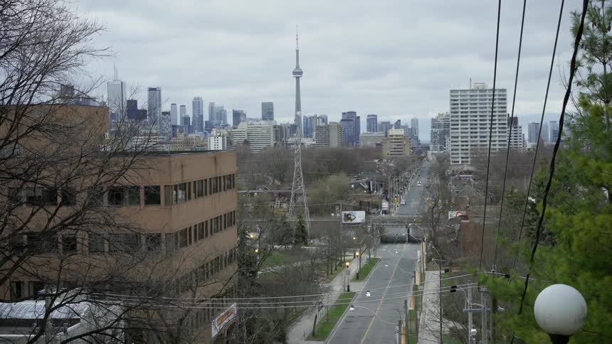 A city street extends towards skyscrapers in the distance